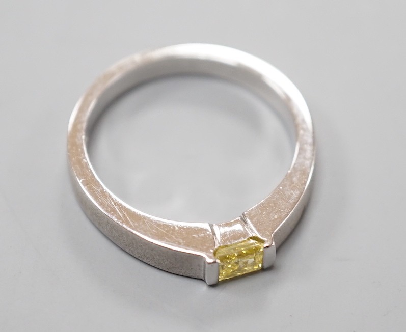 A modern sandblasted platinum and solitaire rectangular cut fancy yellow diamond set ring, size M/N, gross weight 7.2 grams